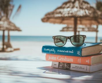 Les héros partent en vacances Pile de livres sur fond de plage