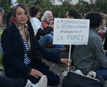 Photo en couleur avec Catherine Ringer parmi un public assis lors d'un meeting