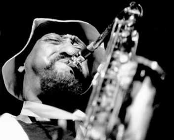 Portrait en gros plan et en noir et blanc de Sonny Rollins jouant du saxophone