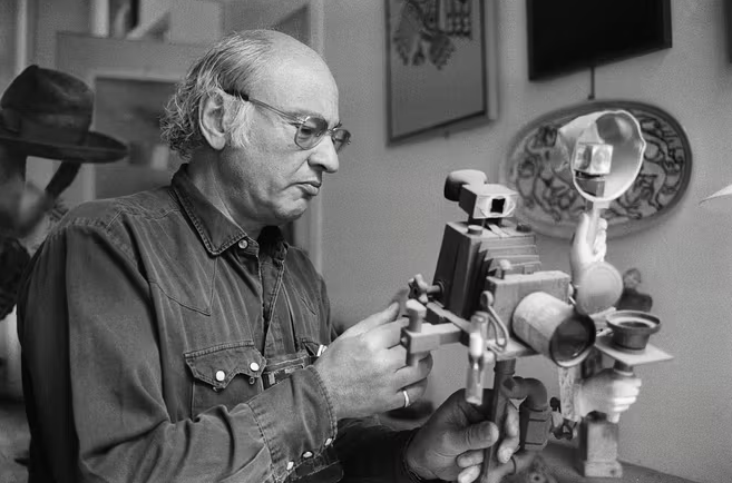Photo en noir et blanc d'Edgar Morin avec un appareil photo dans les mains