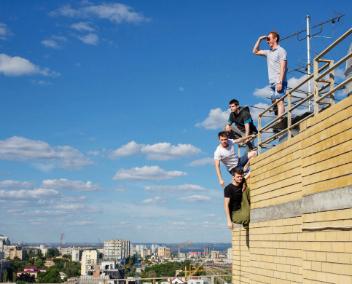 des hommes sur un toit regardent l'horizon