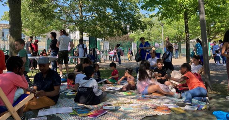 Adultes et enfants en plein air autour de livres