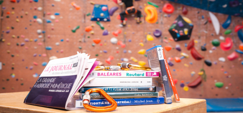 Pile de livres et jeux vidéo dans une salle d'escalade